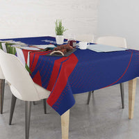 Blue tablecloth with red and green leaf print, white bird motifs, draped over dining table
