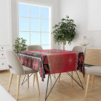 Red and black patterned tablecloth with border design, draped over dining table