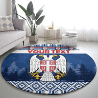 Blue round coat of arms rug with red crest, pine trees, and diamond trim
