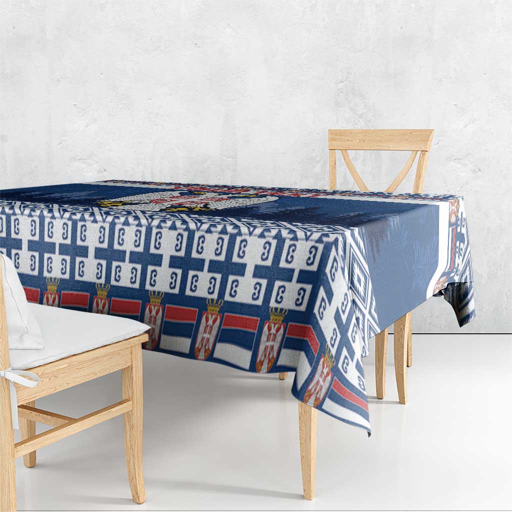 Blue coat of arms tablecloth with repeat motif and geometric border along the edge.