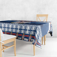 Blue coat of arms tablecloth with repeat motif and geometric border along the edge.