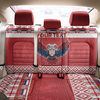 Red car seat cover set with central winged emblem, three headrests, and woven border
