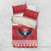 Red bedding set shown flat: duvet and two pillowcases with eagle emblem and festive stripes