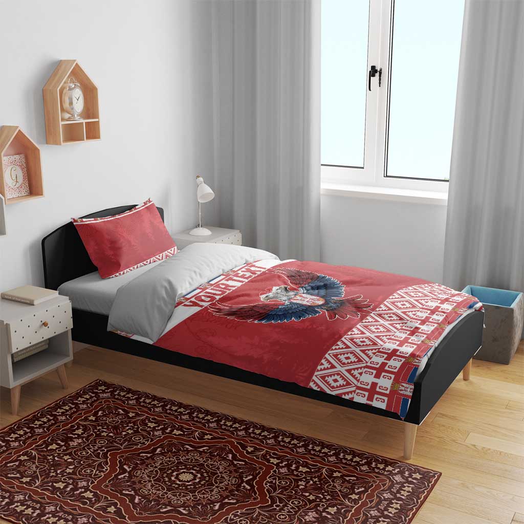 Red personalized bedding on bed: eagle emblem, “YOUR TEXT” band, and patterned edge trim