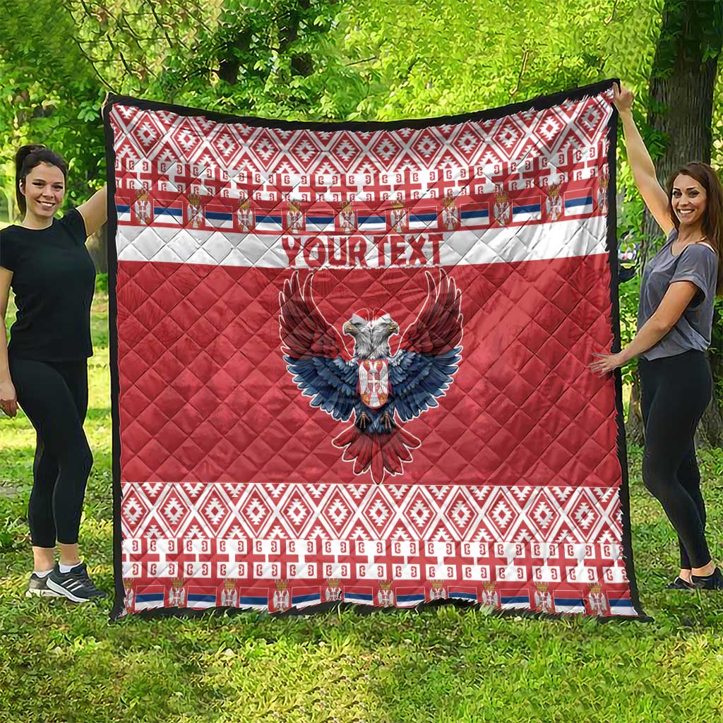 Red quilt outdoors with 'YOUR TEXT' and blue double-headed eagle design, quilted fabric