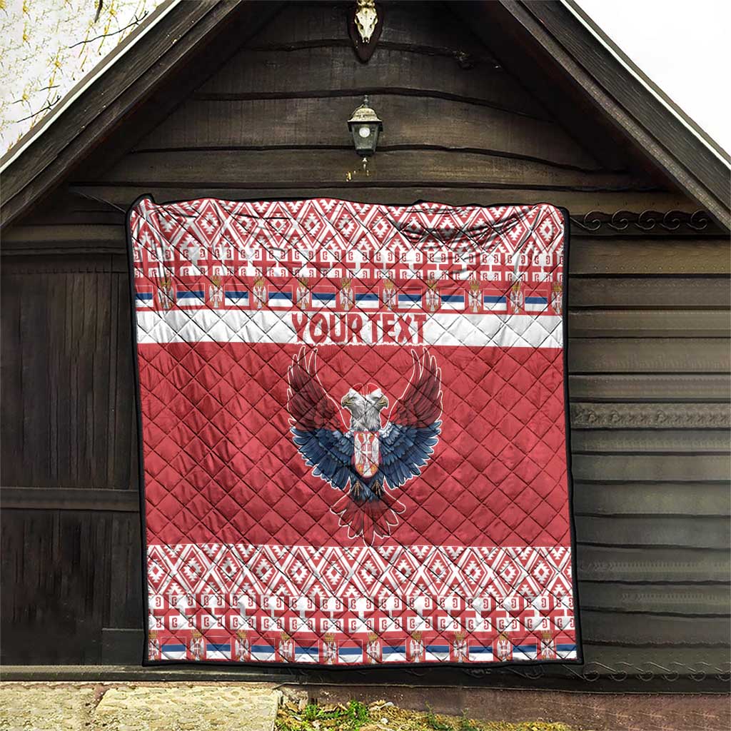 Red quilt hanging on barn wall, 'YOUR TEXT' and double-headed eagle, patterned edges