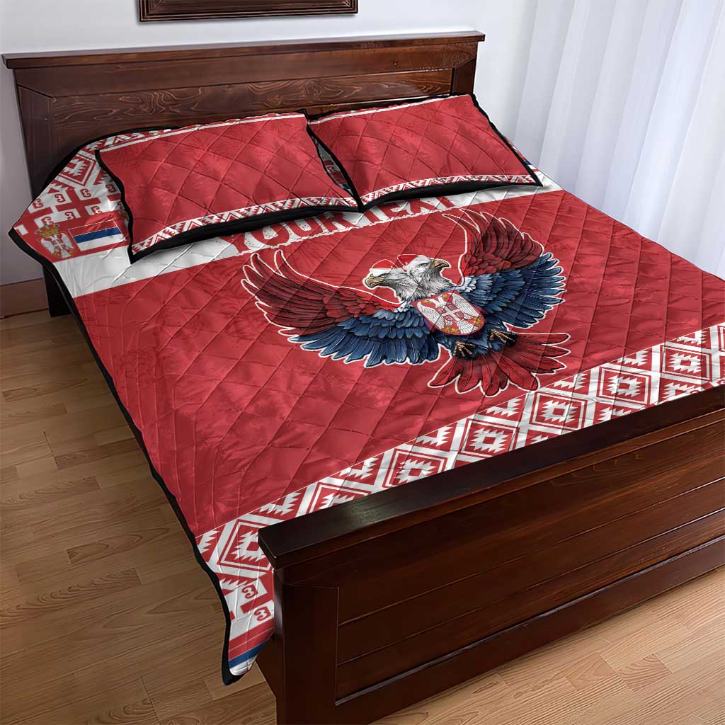 Red quilt bed set with eagle motif and patterned hem, two matching pillows
