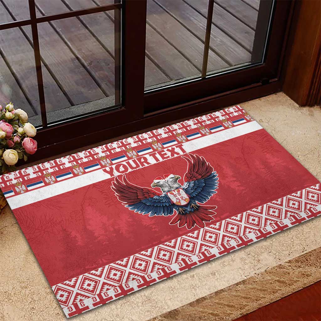Red rubber doormat with custom text, double-headed eagle graphic, and festive border trim