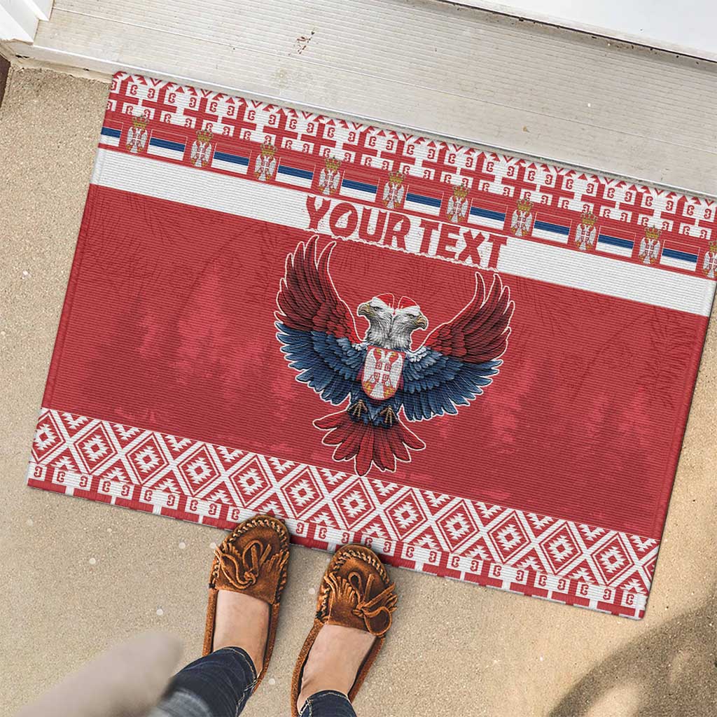Red rubber doormat with eagle emblem and custom text, surrounded by patterned ribbon border