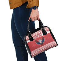 Red and black shoulder handbag with eagle emblem, patterned band, and short top handles