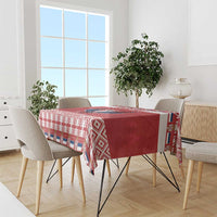 Red and white patterned Christmas tablecloth on dining table with festive border