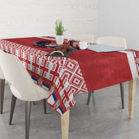 Red Christmas tablecloth with white geometric border and central emblem