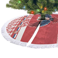 Red round Christmas tree skirt with eagle motif, white geometric panel, and tassel fringe