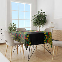 Black Christmas tablecloth with colorful kente zigzag pattern, draped over dining table