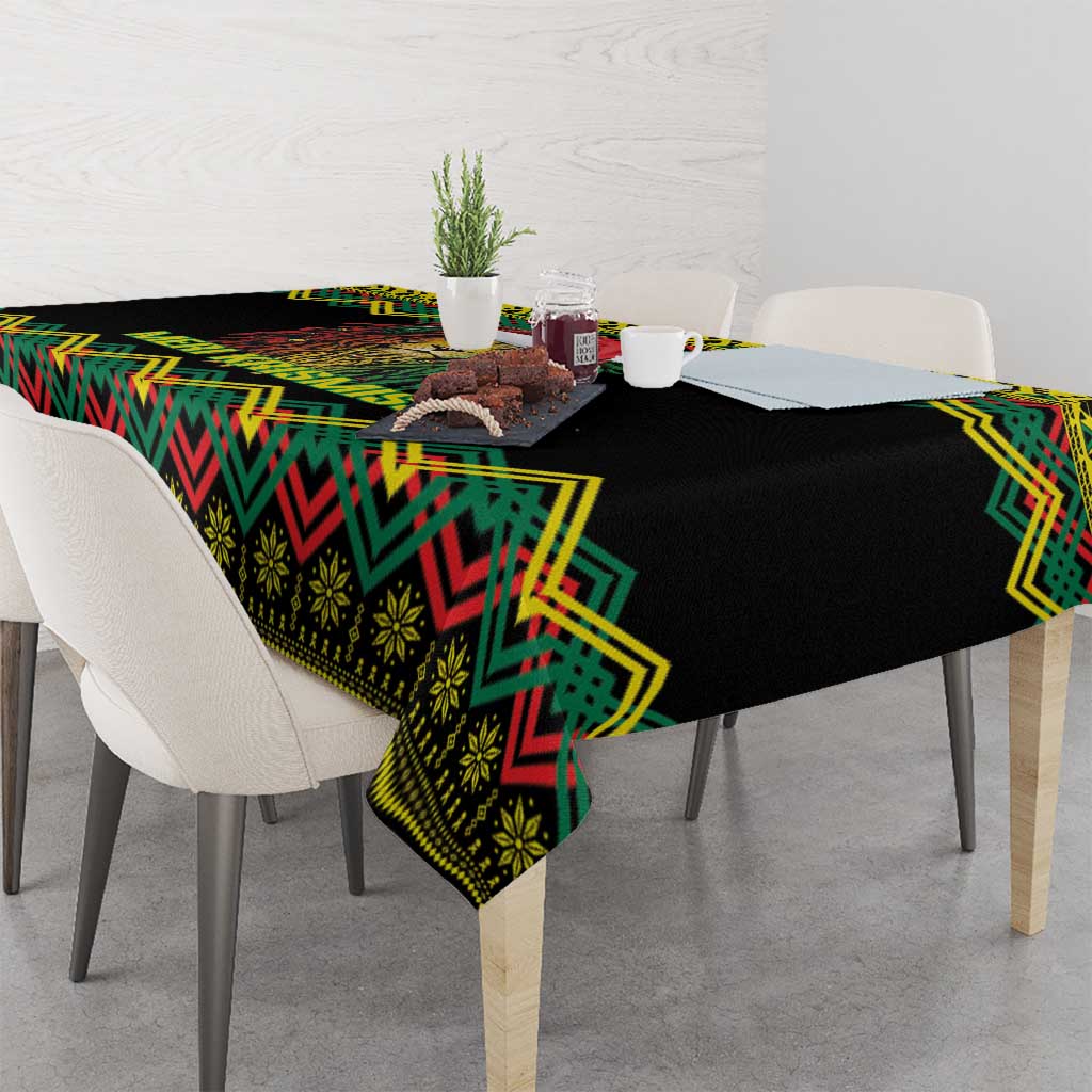 Black tablecloth with colorful kente pattern and lion artwork, draped over table corner