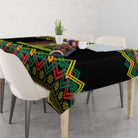 Black tablecloth with colorful kente pattern and lion artwork, draped over table corner