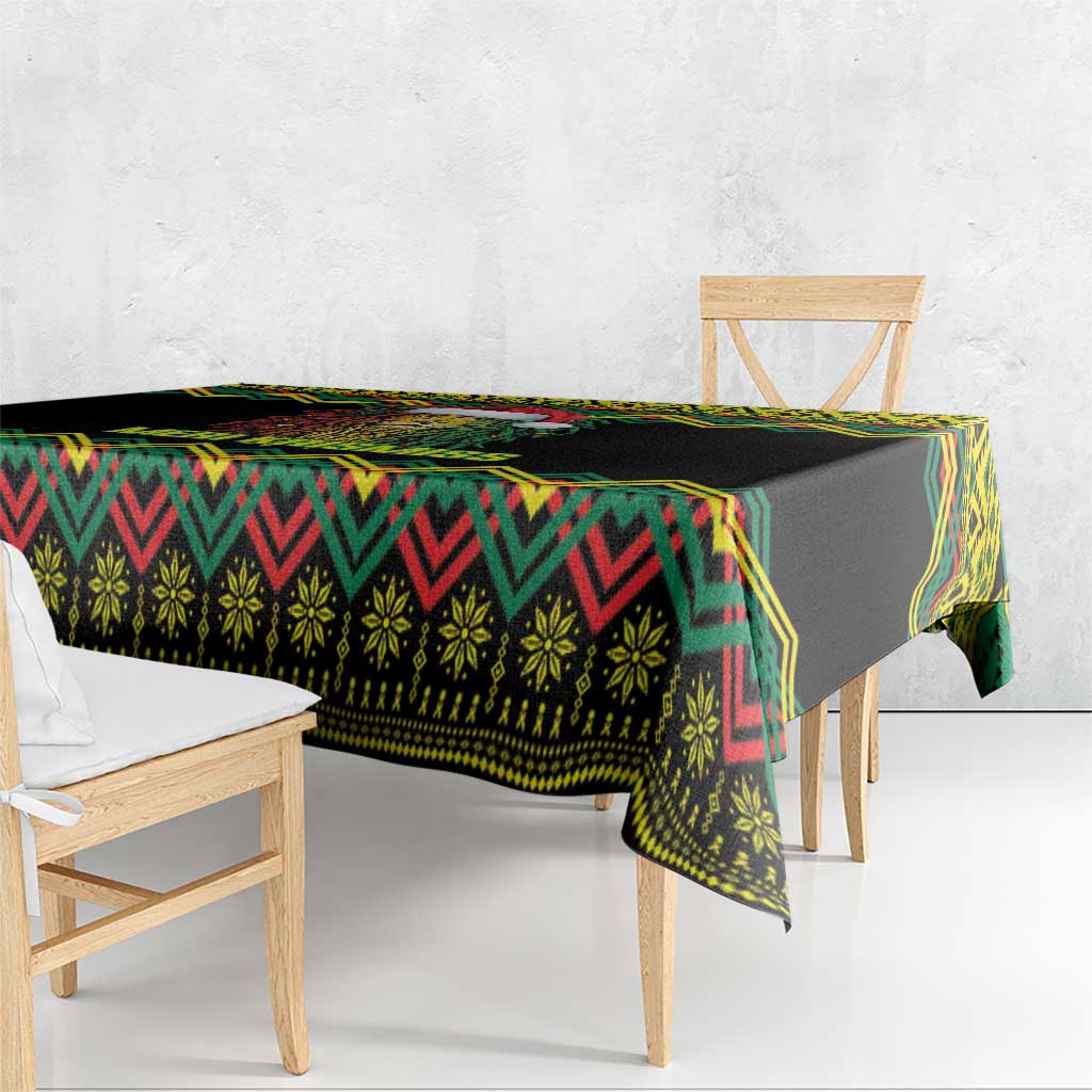 Black Christmas tablecloth with green, red, and yellow kente geometric border