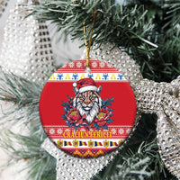 Red round ceramic Christmas ornament with Eurasian lynx, Santa hat, peony flowers, hanging on tree