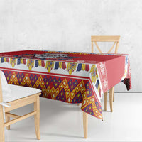 Red tablecloth with colorful geometric border and corner drop