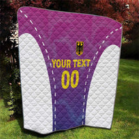 Custom football quilt laid on grass: purple-pink center jersey with white quilted edges.