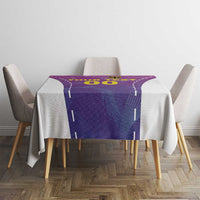 Purple custom football tablecloth with yellow design, draped over small dining table