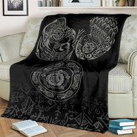 Black Nordic blanket on cream armchair with raven and circular medallion print