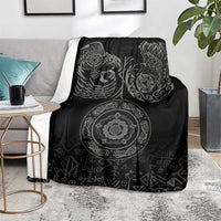 Black Nordic blanket on gray couch with raven and ornate circular medallion