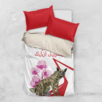 White bedding set with red pillowcases, hyena and pink flower graphic on duvet top.