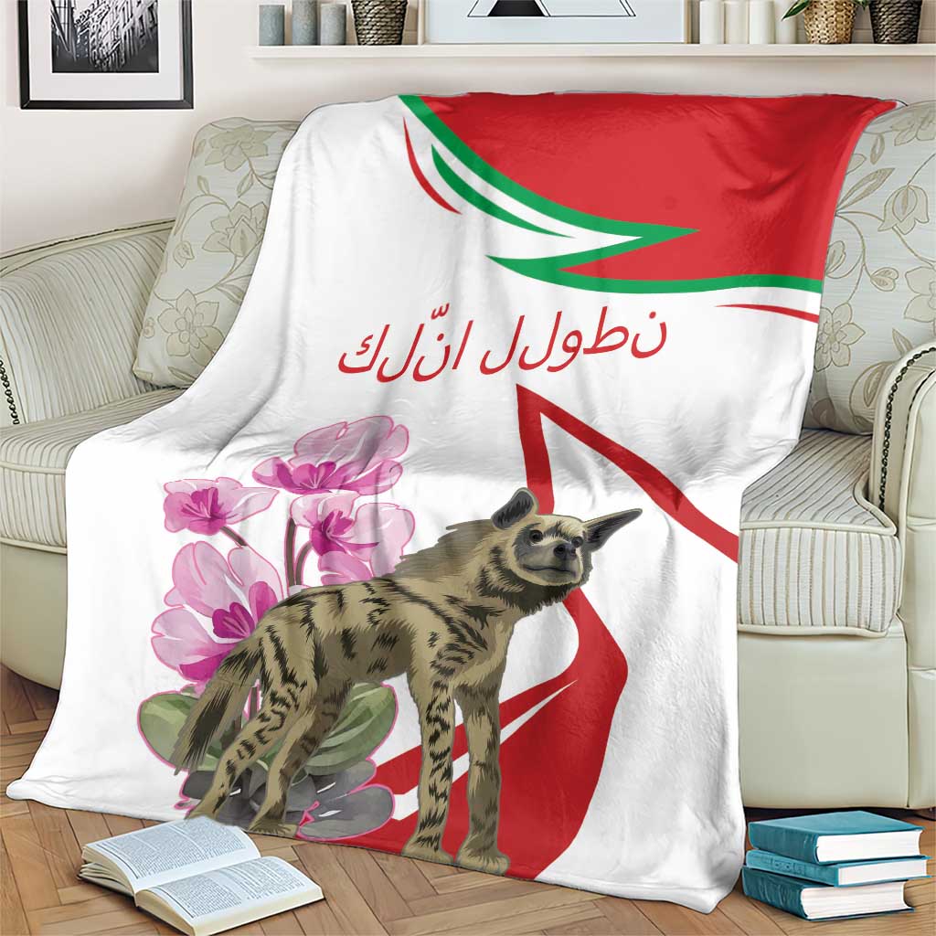 White blanket draped on a couch, showing red and green stripes, pink cyclamen flowers, hyena.