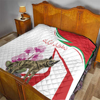 Quilt on bed with white quilting, red-and-green striped design, purple flowers, hyena