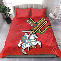 Red duvet and two pillows with knight-on-horse coat of arms design and colorful shield lines