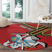 Red round carpet showing a knight with spear beside a blue cross shield
