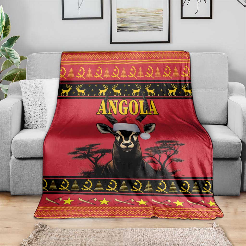 Red Angola Christmas blanket draped over gray sofa with antelope portrait center and dark border