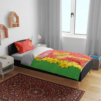 Eritrean bedding set on bed with green comforter, yellow flowers, red pillows, and ERITREA text