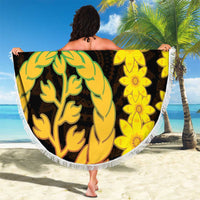 Round beach blanket with fringe, yellow floral and green tree coat-of-arms on dark background