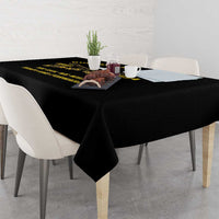 Black tablecloth draped over a dining table with yellow text slogan across top