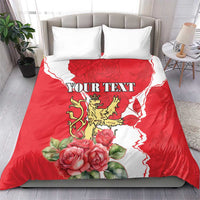 Red personalized duvet cover with lion crest, roses, white pattern, and two white pillows