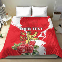Red personalized bedding set with lion crest, roses, white pattern, and two white pillows