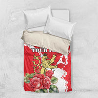 Red personalized bedding set with lion crest, roses, white pattern, and two white pillows