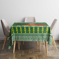Green square tablecloth with banana row pattern and green diamond border, on dining table