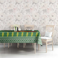 Green tablecloth with repeating leaf and diamond patterns along the center, on dining table