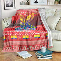 Red Feliz Navidad blanket spread on a sofa with condor graphic and repeating motifs