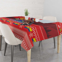 Red Christmas tablecloth featuring condor artwork, patterned borders, and festive icons