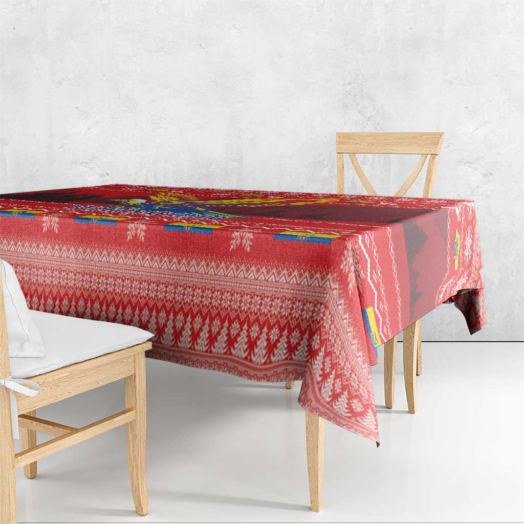 Red Christmas tablecloth with patterned trim, condor imagery, and repeating snowflake icons