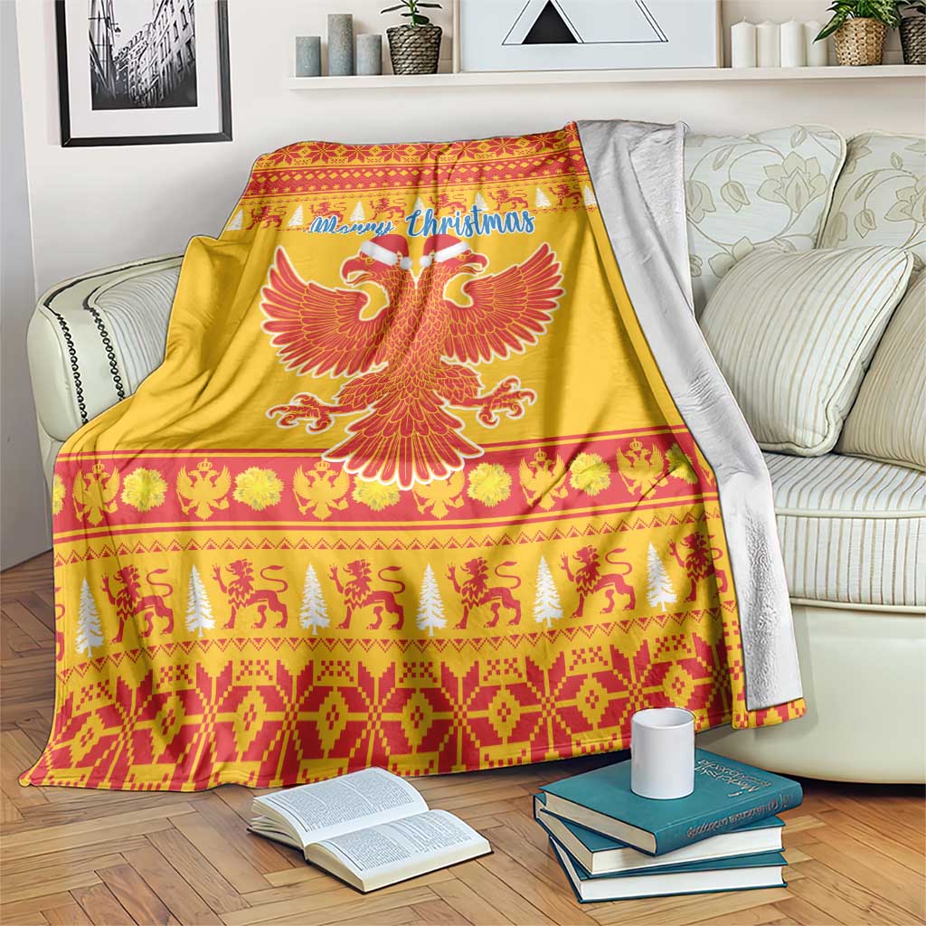 Yellow Christmas blanket on a sofa bed, with Merry Christmas script and red eagle emblem.