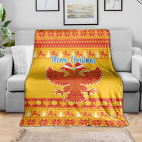 Yellow Christmas blanket draped over a sofa, featuring Merry Christmas and a red double-headed eagle.