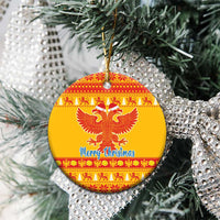 Round yellow ceramic ornament with red double-headed eagle and 'Merry Christmas' text, hanging