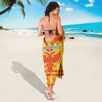 Yellow Christmas sarong with red eagle motif and Merry Christmas text, worn