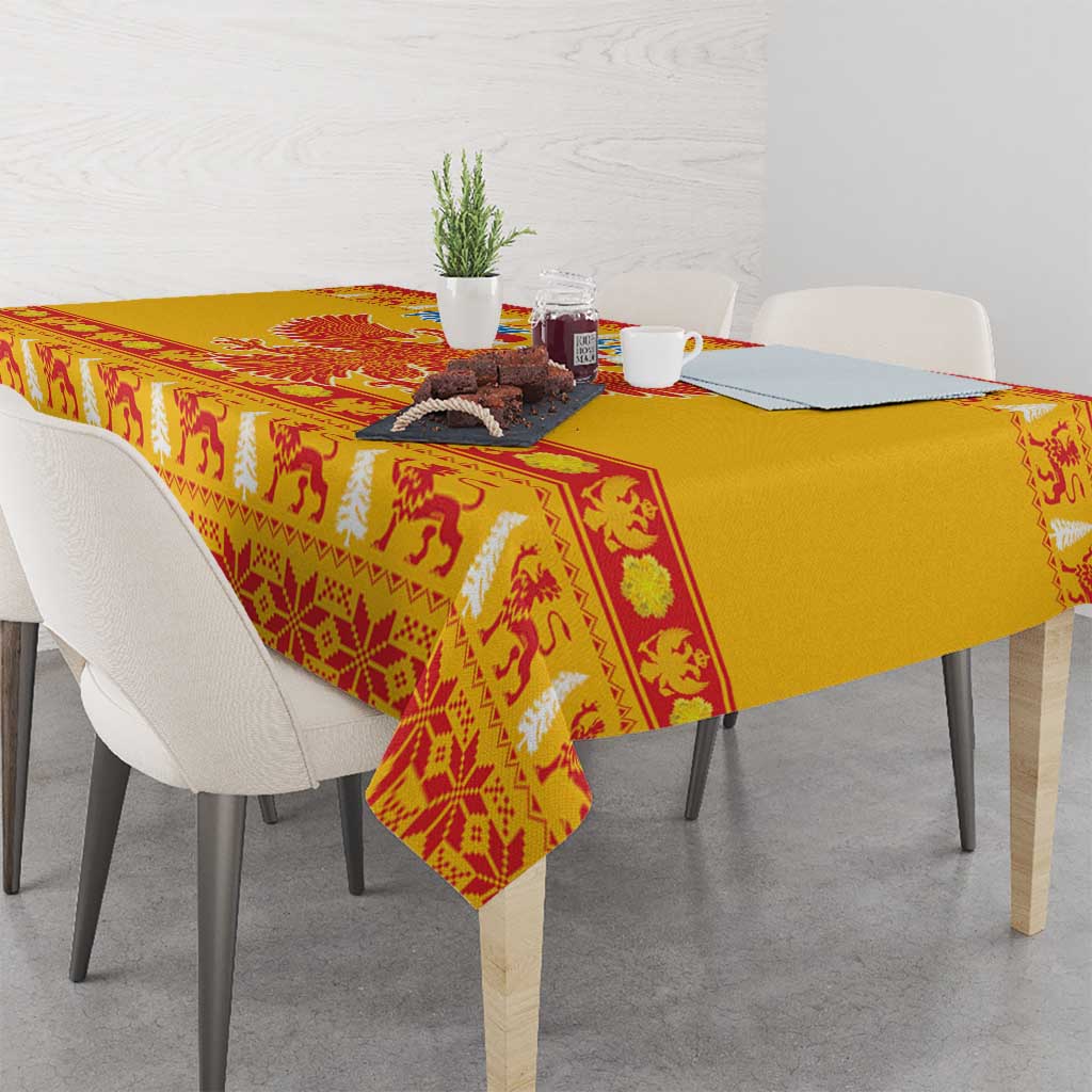 Yellow Christmas tablecloth draped over table edge with red patterned border