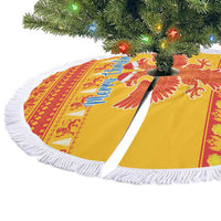 Yellow round tree skirt with eagle design and white fringe around hem